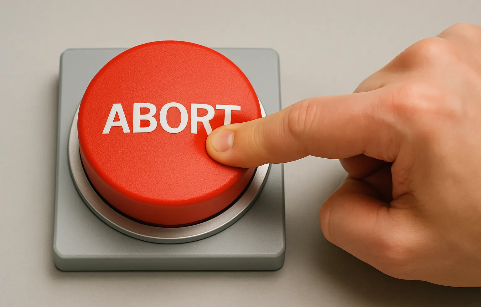 A hand pressing a red abort button.